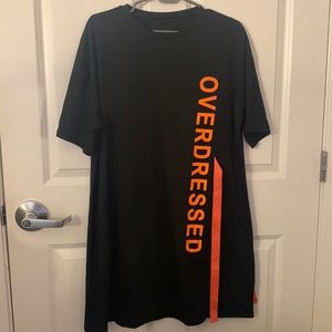 Black t shirt dress with lettering, “overdressed” down the side in orange